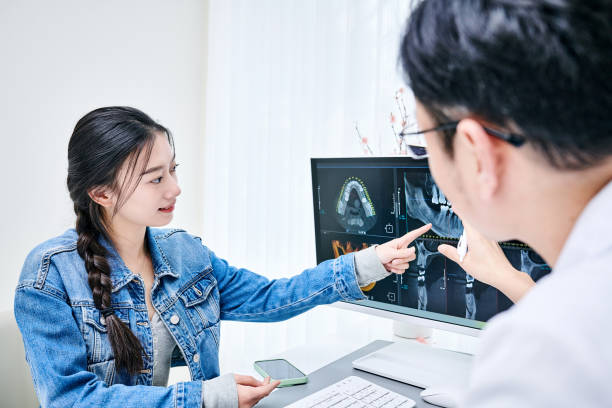 a dentist and patient looking at a dental x-ray